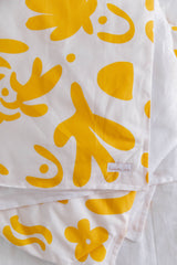 Yellow colour bomb with white linen cot quilt